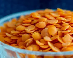 Step <p>Añade las lentejas, el agua, el laurel, la pastilla de caldo de verduras, el azúcar, la sal y la pimienta. Mezcla con la espátula. Coloca el cestillo sobre la tapa en lugar del cubilete y programa el tiempo que indique el paquete de lentejas/100°C/giro inverso/vel 2. Retira la hoja de laurel. </p> illustration